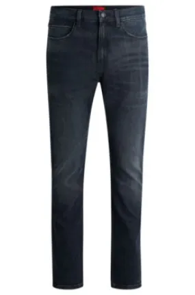 Vaqueros slim fit de denim elástico con efecto desgastado